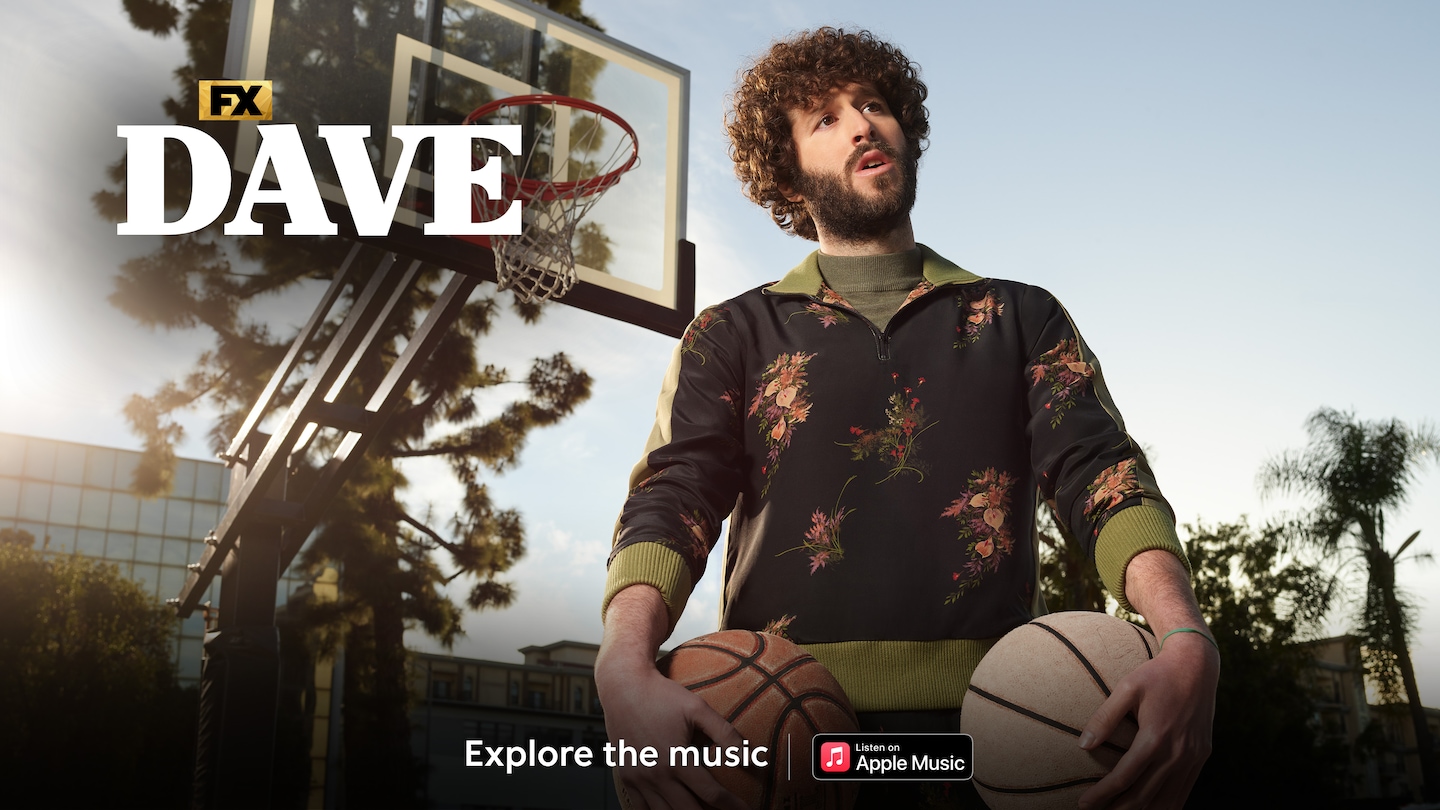 Image of DAVE holding two basketballs underneath a basketball hoop.