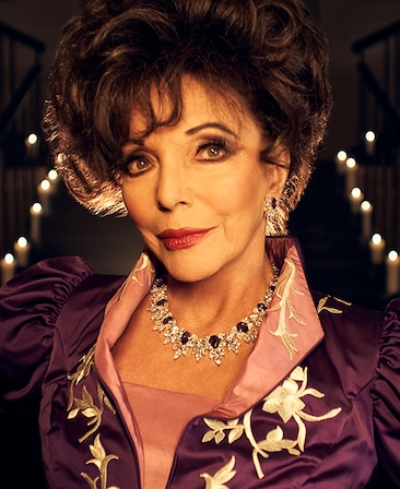 Joan Collins headshot in purple and pink dress with gold embroidery and candles in background from AHS Apocalypse