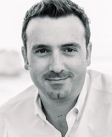 Dane Lillegard headshot wearing a white shirt in black and white filter