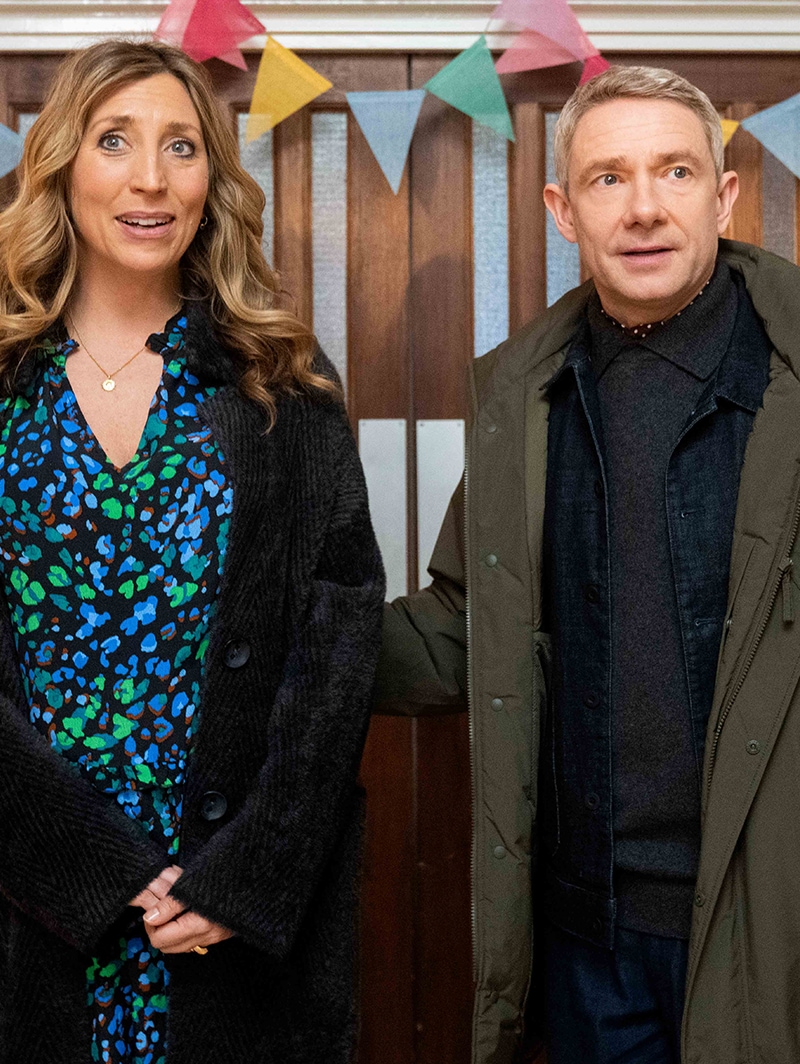 Ally and Paul standing next to each other in front of a wood door.