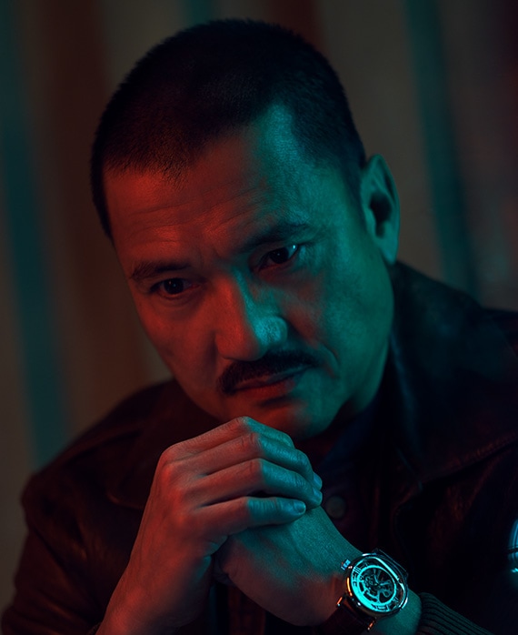 Jon Jon Briones sitting with his hands clasped together for FX's Class of '09