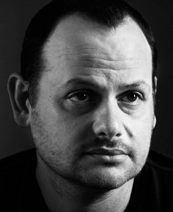 Gideon Raff headshot wearing black shirt in black and white