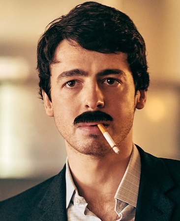 Anthony Boyle as Brendan Hughes in a button up and blazer, and a cigarette in his mouth.