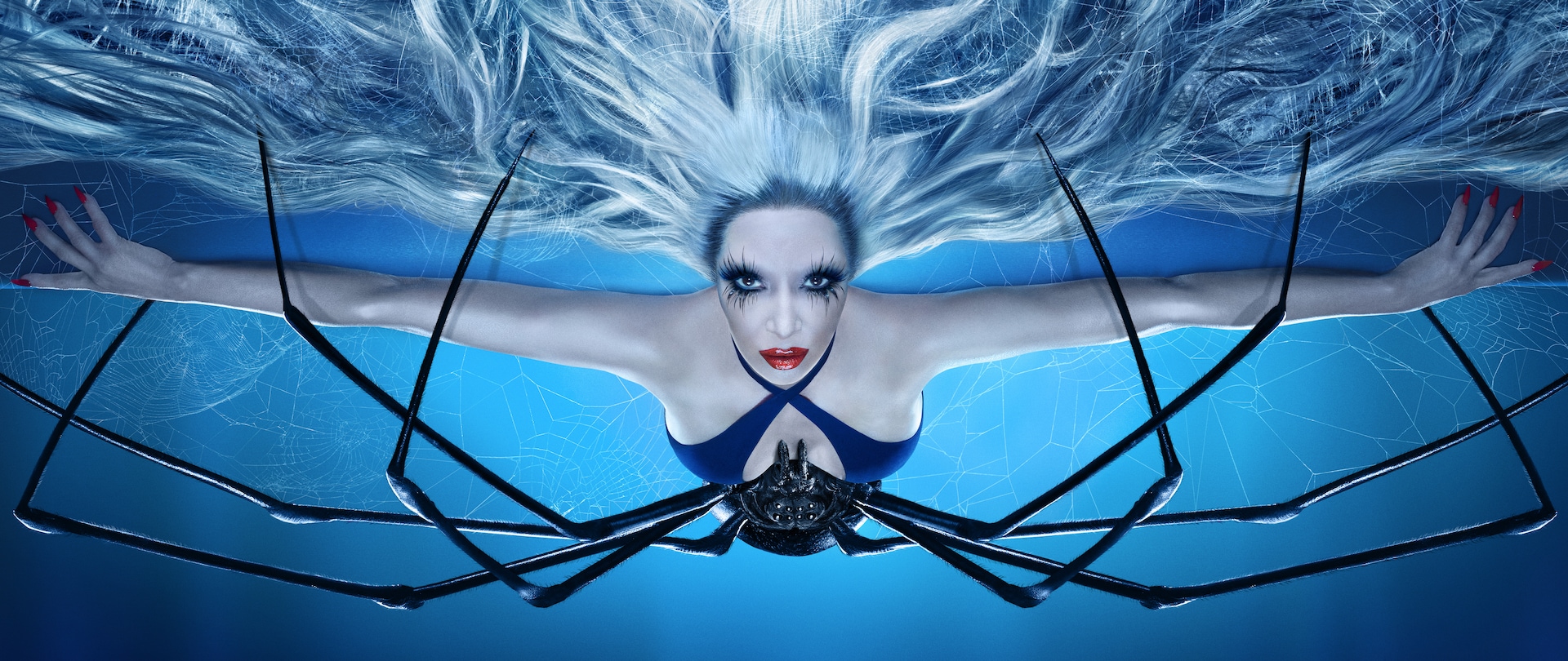 Woman with platinum hair and a spider on her belly