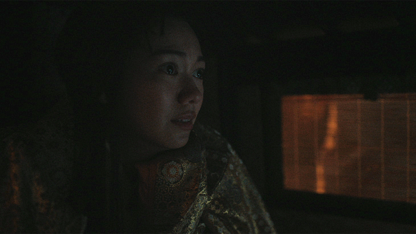 A tearful Ochiba sits in a palanquin wrapped in a gold pattern uchikake