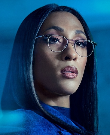 Michaela Jaé Rodriguez headshot wearing glasses and a navy jacket for AHS: Delicate