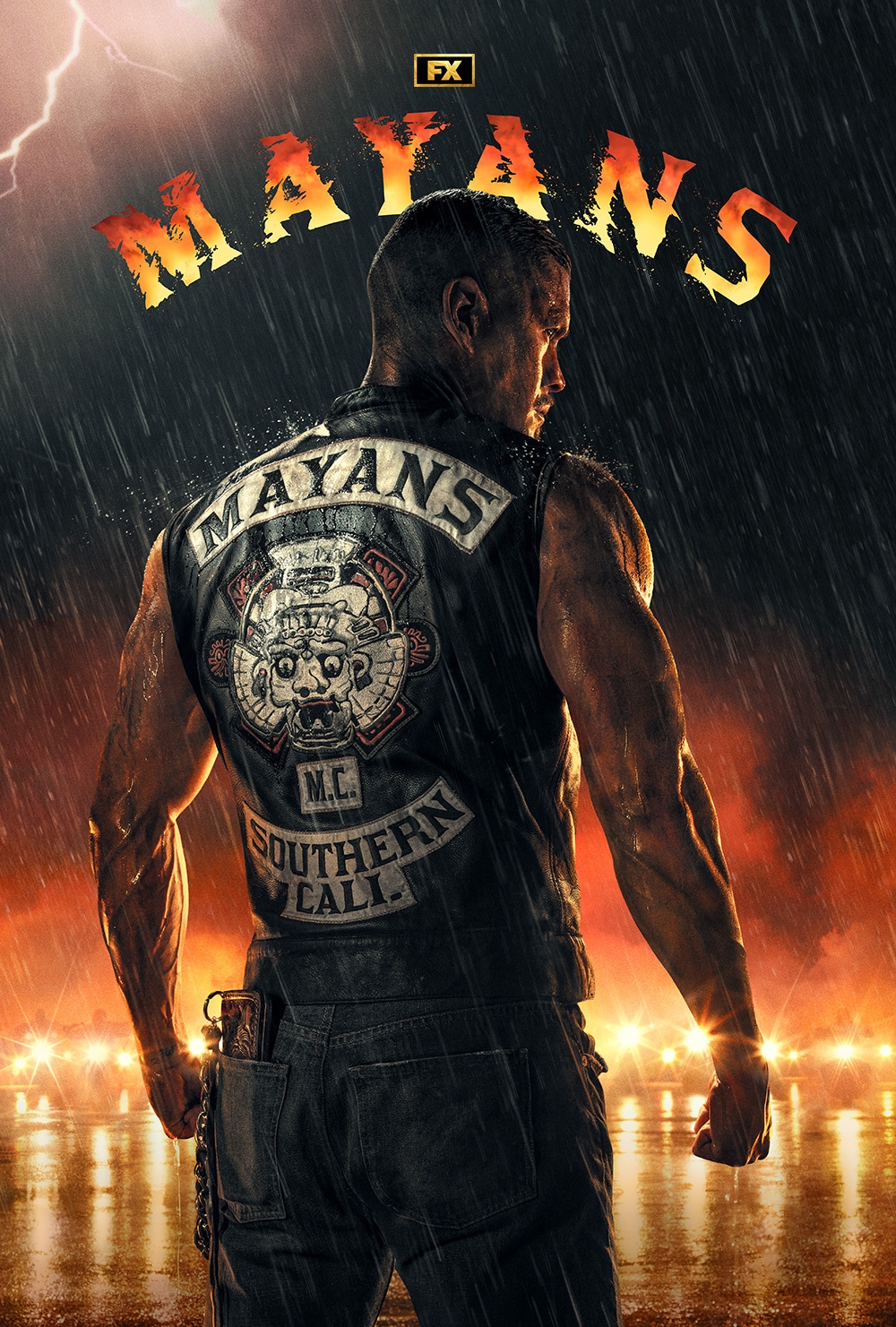 JD Pardo in front of fire and motorcycle gang with back turned to show leather Mayans MC vest