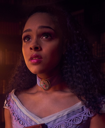 Ashley Santos headshot looking up in purple dress and purple necklace from American Horror Story Apocalypse