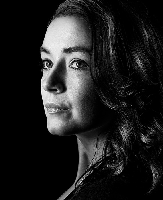 Sarah Bolger headshot wearing a black top and curls in her hair