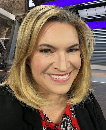 Headshot of Ramona Shelburne wearing a red patterned shirt and black jacket.