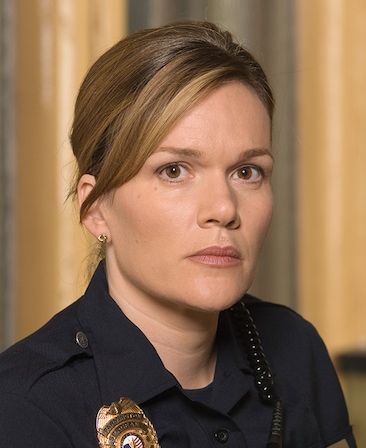 Catherine Dent headshot wearing a police badge and black uniform
