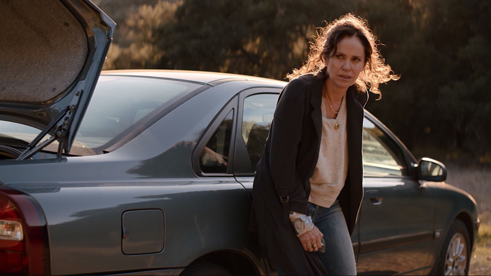 Zoe leaning against the side of a car