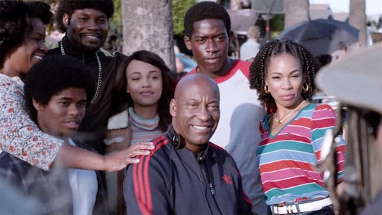John Singleton and Snowfall cast on set smiling for a photo