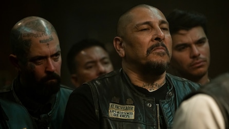 Man wearing a leather biker jacket with a badge that read "El Pacificador Los Asesinos De Dios"
