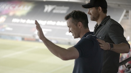 Ryan Reynolds placing his hand on Rob McElhenny's nack