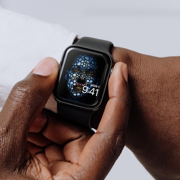 Man wearing Apple Watch with lock screen of blue woman covered in honeycomb pattern net and bees from FX's AHS Cult