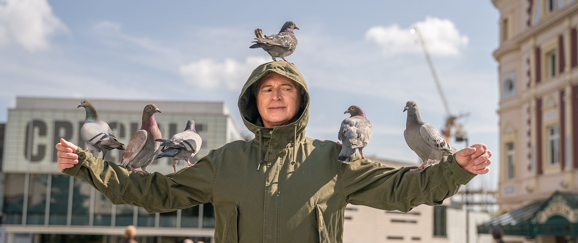 Gaz wearing a green jacket with a hood over his head