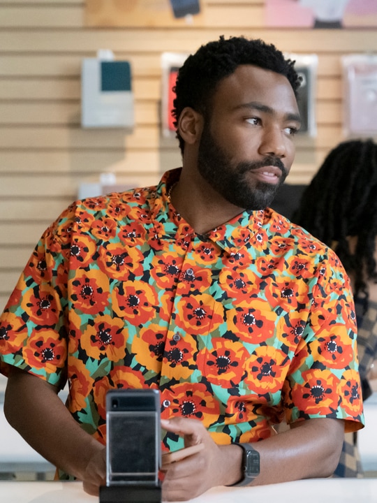 Donald Glover wearing an orange floral shirt