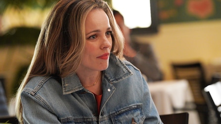 Rachel McAdams wearing a denim jacket sitting in a restaurant.