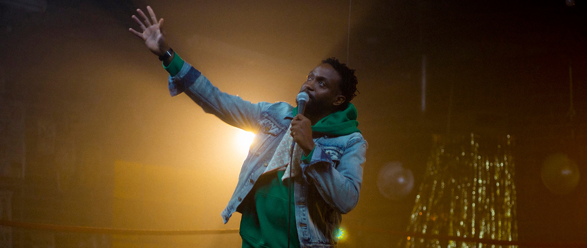 Byron Bowers on stage with a mic