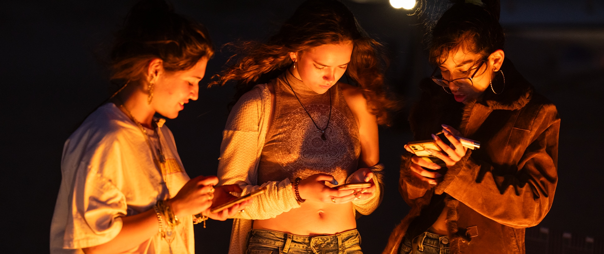 Three girls looking at their phones.