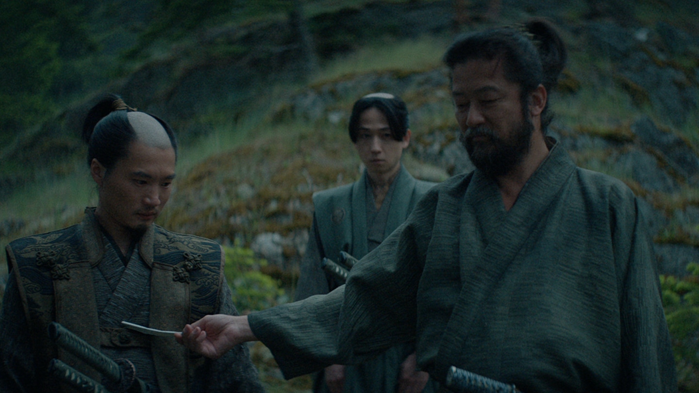 Yabushige passes a piece of paper to Omi as his kosho looks on