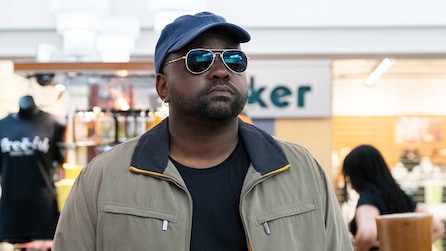 Brian Tyree Henry in aviator sunglasses and blue cap outside in shopping center in FX's Atlanta