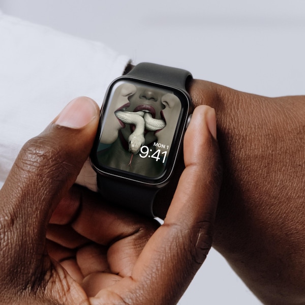 Man wearing Apple Watch with lock screen of three women with white snake moving through their open mouths for FX's AHS Coven