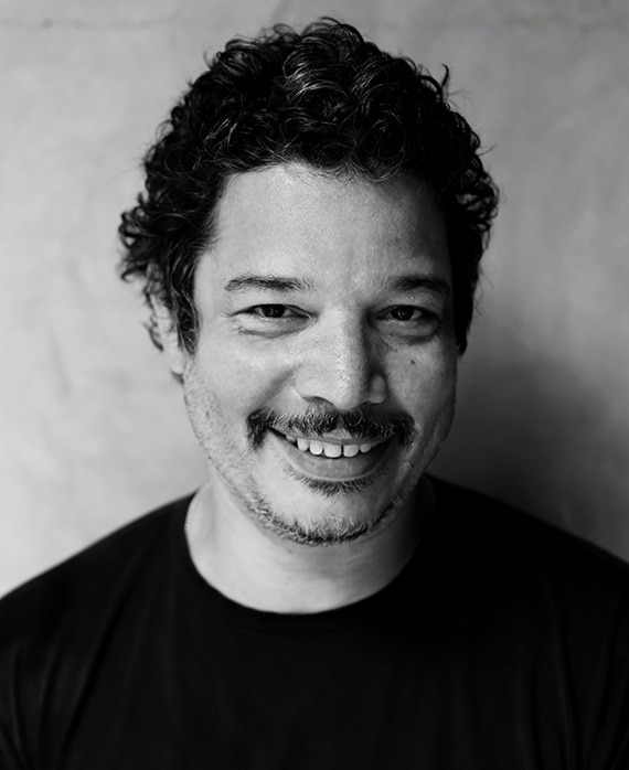 Headshot of Kevin Bray wearing a black shirt in a black and white filter.