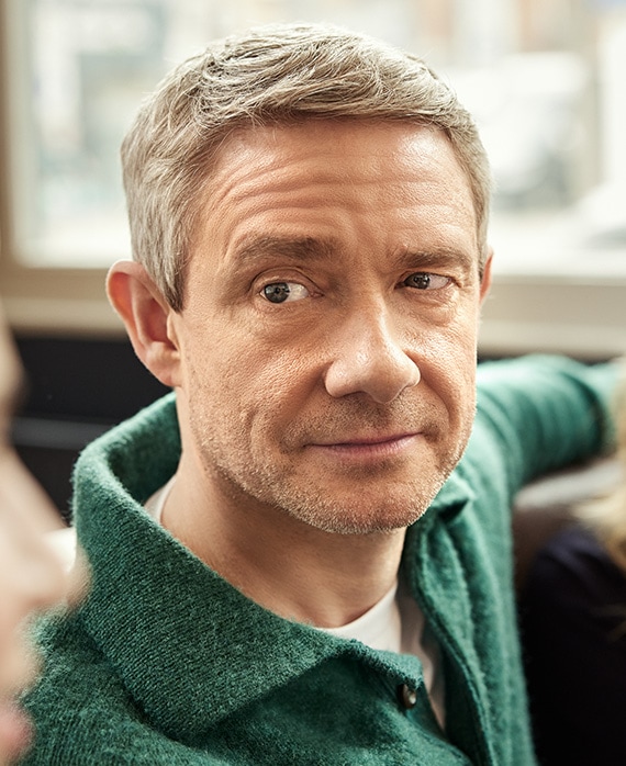 Martin Freeman headshot wearing a green shirt and sitting by a window.