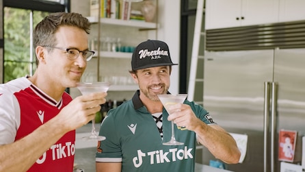 Ryan Reynolds and Rob McElhenney holding martinis and smiling