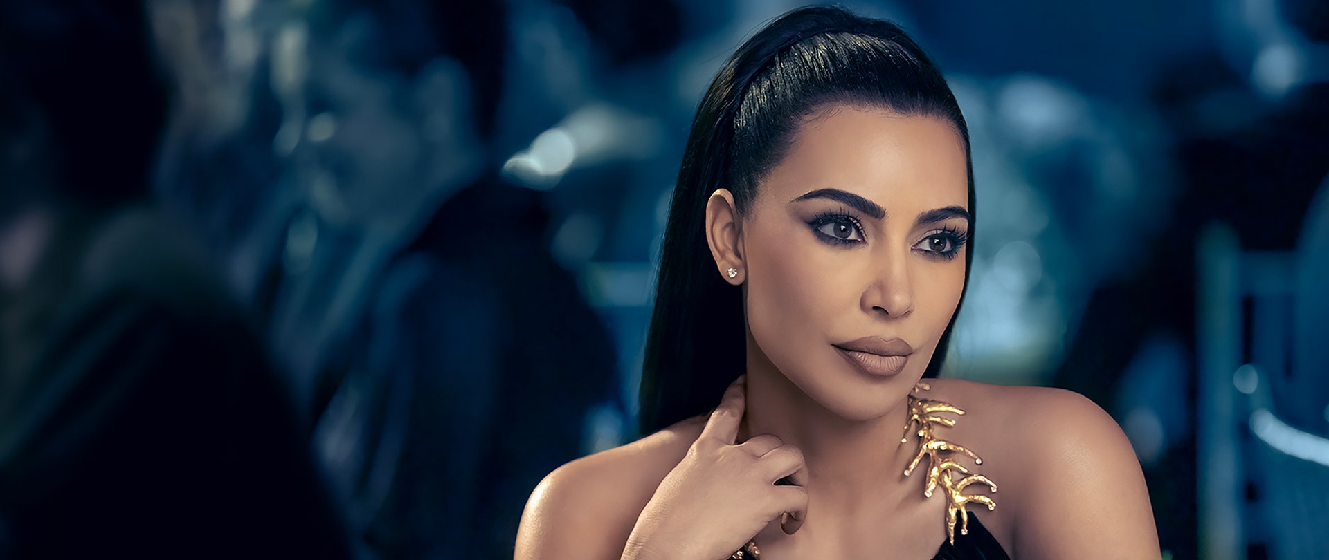 Kim Kardashian as Siobhan in FX's AHS Delicate wearing a black top with gold metal detailing.