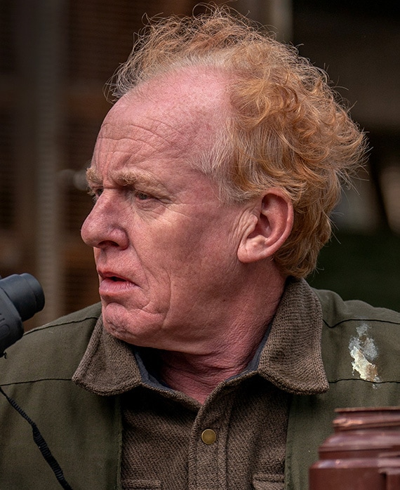 Steve Huison wearing a brown shirt and green jacket 