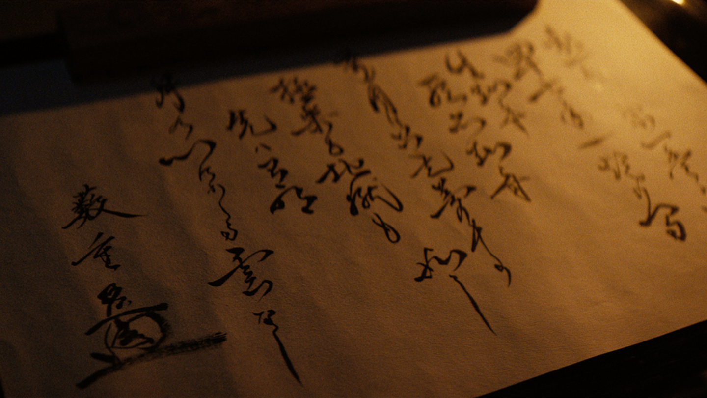 Close up of Lord Yabushige's handwritten will lit by candlelight