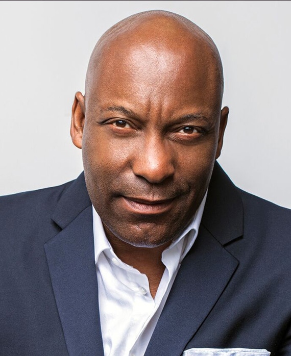 John Singleton headshot wearing a navy suit and white shirt