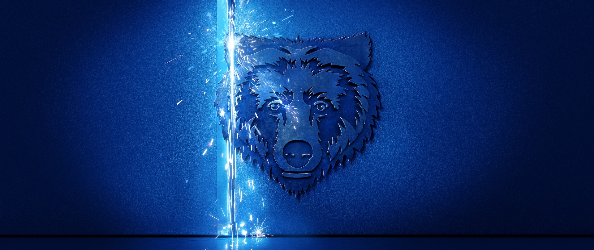 Blue themed image of a grizzly bear’s head cut into metal with white sparks flying down on the left.