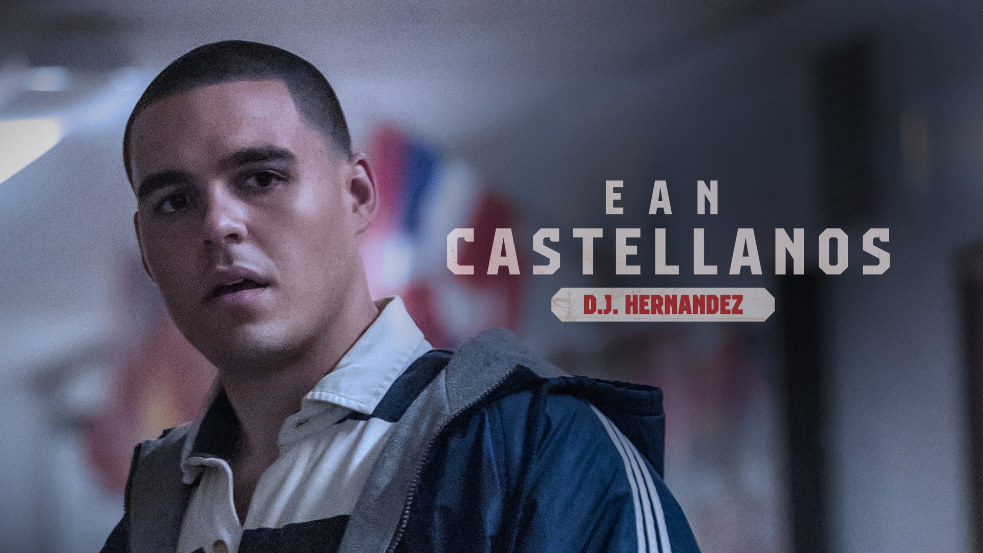 Ean Castellanos as D.J. Hernandez wearing a striped polo and blue athletic jacket looking down.