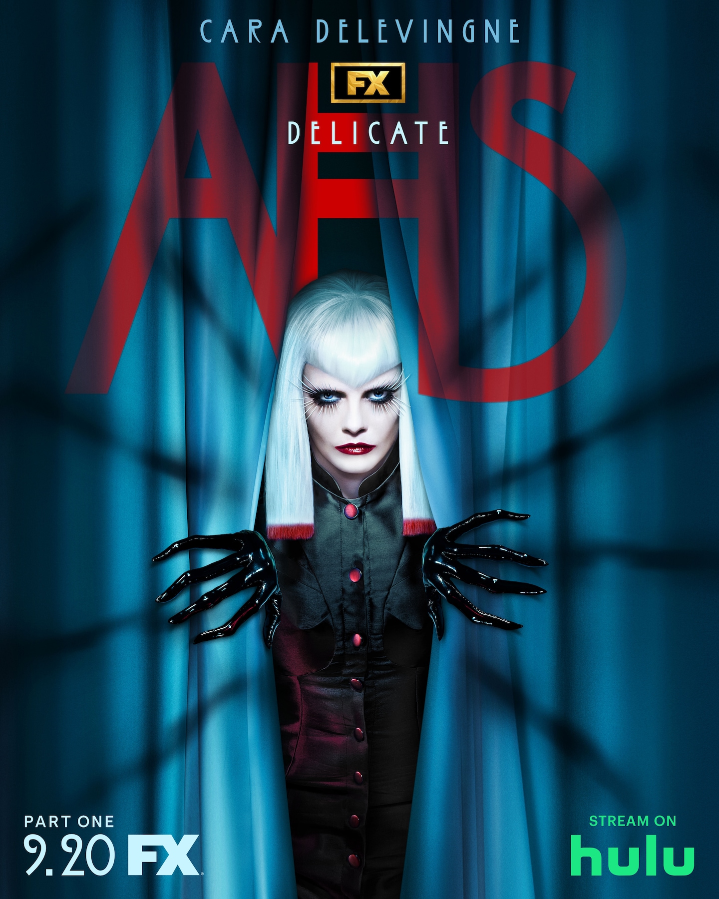 A woman with white hair wearing black latex gloves and peaking out of a gray curtain for AHS: Delicate