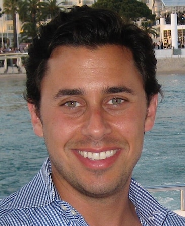 Nick Frenkel wearing a blue checkered shirt, sitting on a boat.