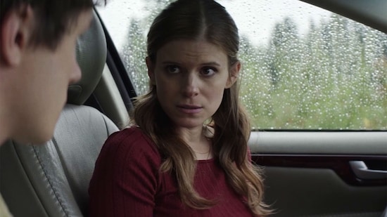 Kate Mara sitting in the driver seat of a car with rain on the window
