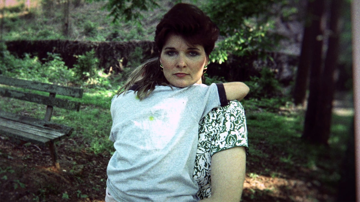 Young Faye Yager in black and white top holding child in a park from Children of the Underground documentary