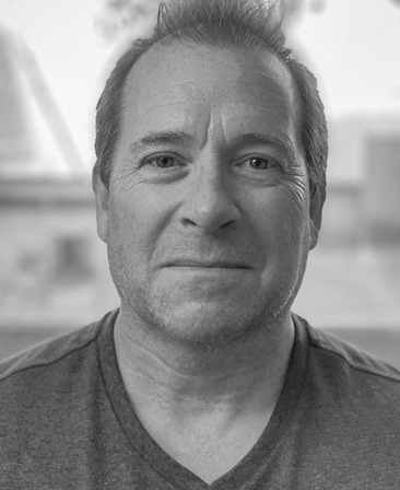 Jeff Luini headshot in black and white wearing a v-neck shirt