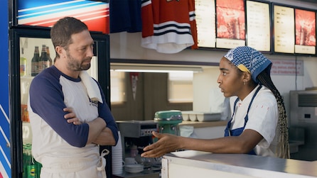 Ayo Edebiri as Sydney talking to Ebon Moss-Bachrach as Richie in restaurant by drink cooler in FX's The Bear