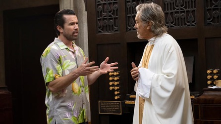 Mac in grey Hawaiian shirt talking to priest inside church in FX's It's Always Sunny