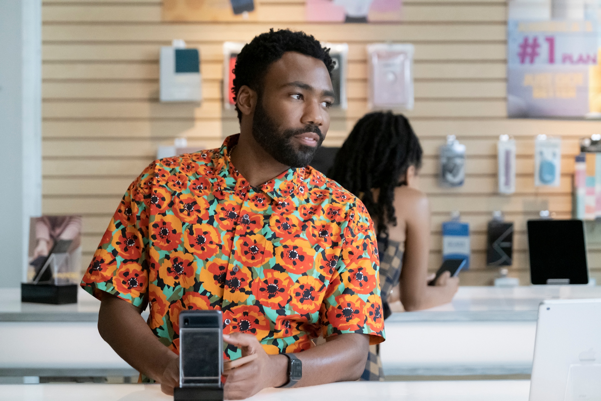 Donald Glover as Earn Marks waiting in a mobile device store