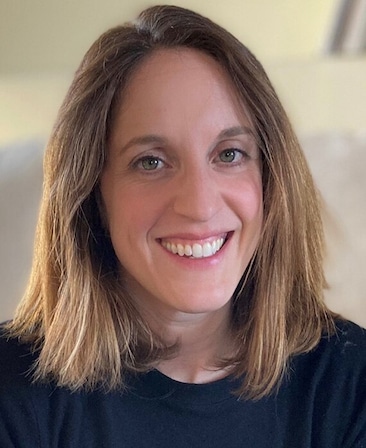 Headshot of executive producer Alicia Van Couvering, wearing a black tshirt with shoulder length brown golden hair.