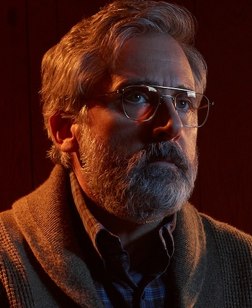 Steve Carell headshot wearing glasses and a thick sweater with plaid shirt