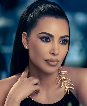 Kim Kardashian headshot wearing a black top with gold metal detailing for AHS: Delicate