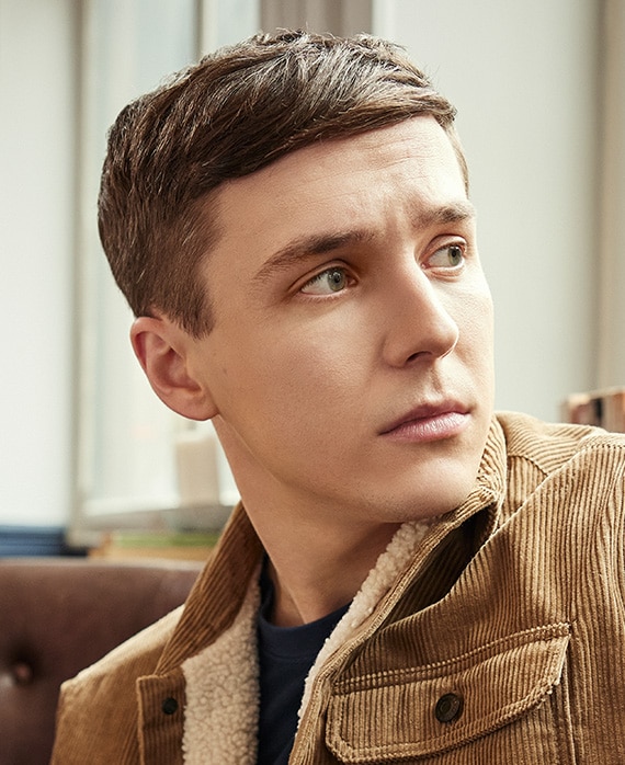 Oscar Kennedy headshot wearing a brown jacket with shearling lining.