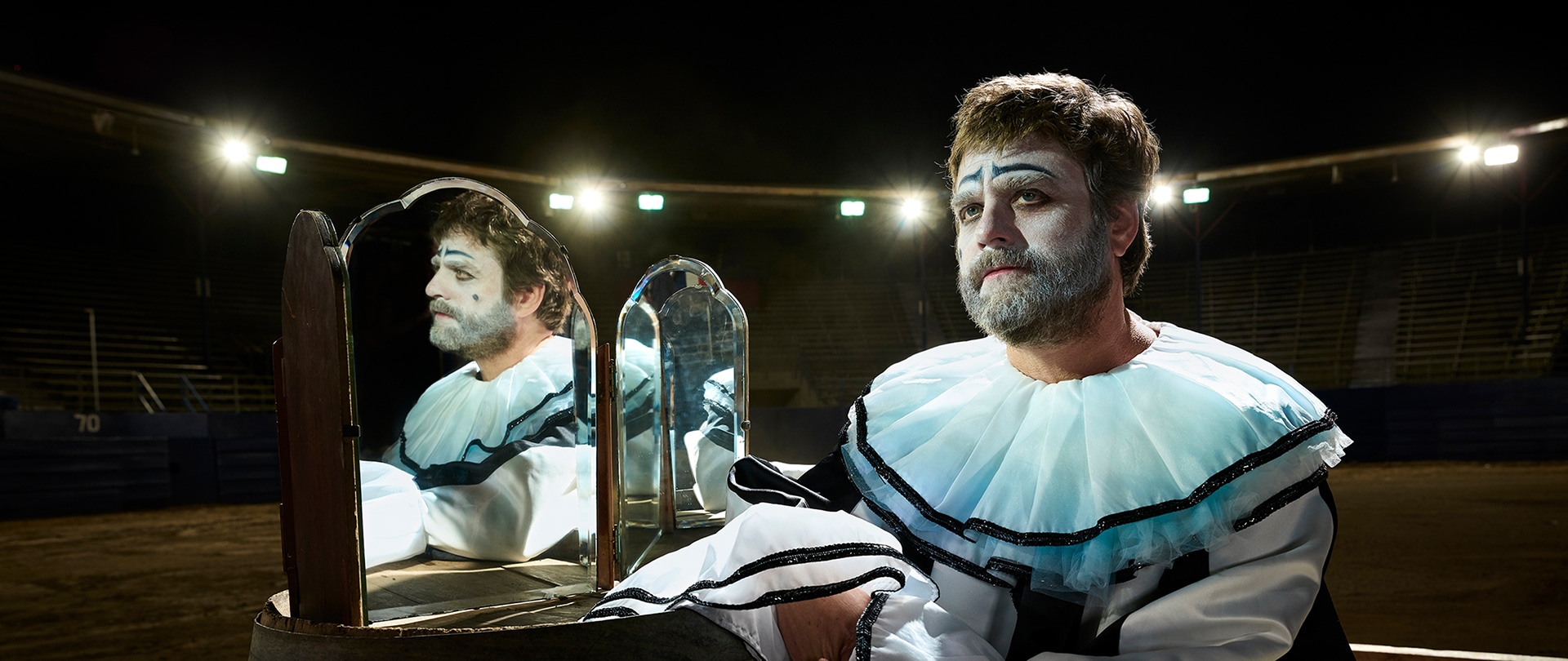 Zach Galafianakis as Chip Baskets for FX's Baskets in clown attire with mirrors to his side.